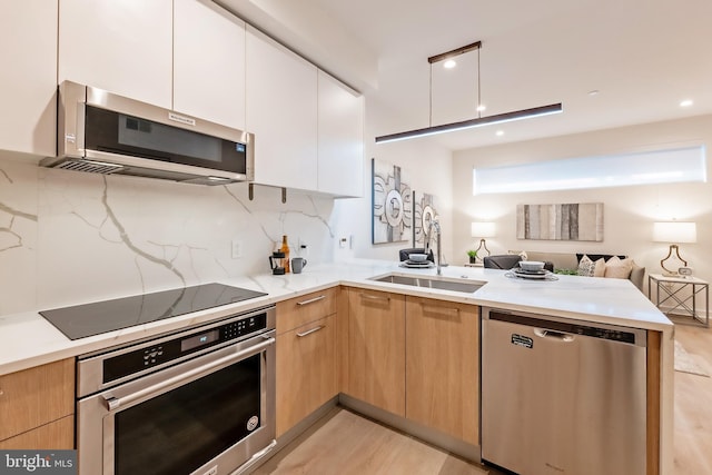 kitchen with ventilation hood, appliances with stainless steel finishes, tasteful backsplash, and white cabinetry