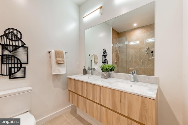 bathroom with a tile shower, tile patterned floors, vanity, and toilet