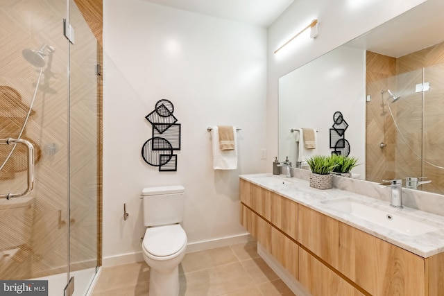 bathroom with tile patterned flooring, a shower with door, vanity, and toilet