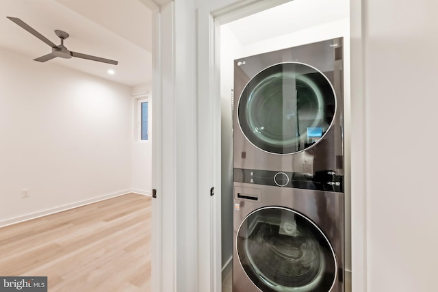 laundry area featuring wood-type flooring, stacked washing maching and dryer, and ceiling fan