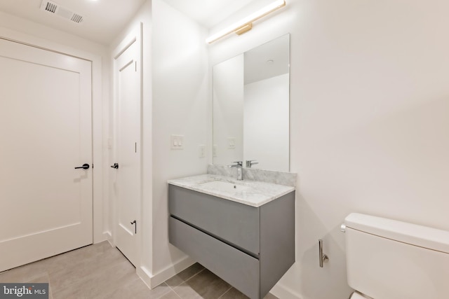 bathroom with tile patterned floors, vanity, and toilet