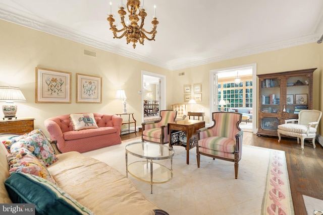 living room featuring ornamental molding, wood-type flooring, and a chandelier