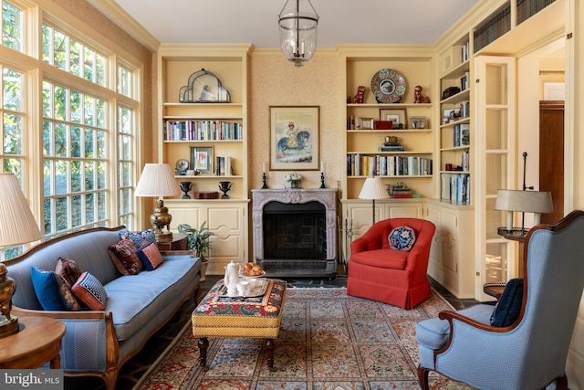 living area with ornamental molding, a premium fireplace, and built in features