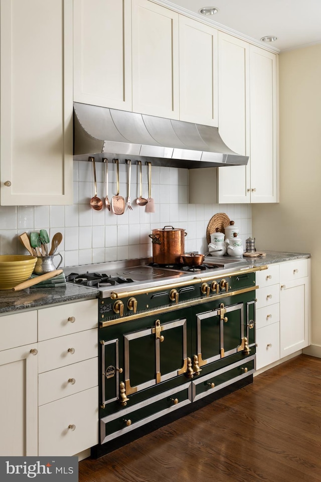 kitchen with cooktop, white cabinetry, tasteful backsplash, ventilation hood, and dark stone counters