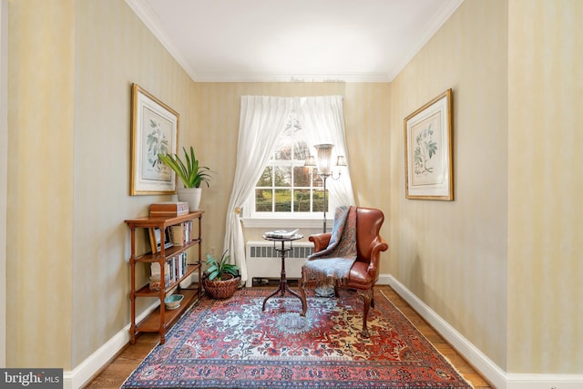 living area featuring radiator, hardwood / wood-style flooring, and ornamental molding