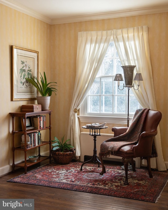 sitting room with crown molding and hardwood / wood-style floors