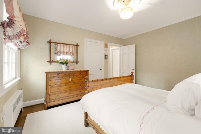 bedroom featuring ornamental molding, dark hardwood / wood-style flooring, and radiator