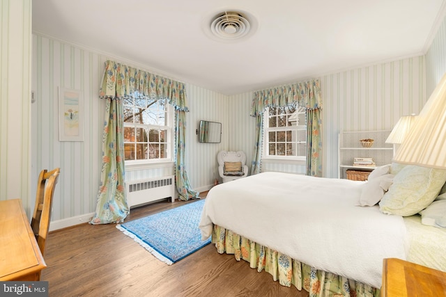 bedroom featuring crown molding, radiator, and hardwood / wood-style flooring