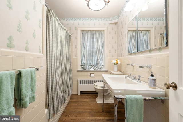 bathroom with hardwood / wood-style flooring, radiator heating unit, and toilet