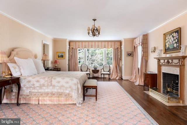 bedroom featuring crown molding, wood-type flooring, a high end fireplace, and a notable chandelier