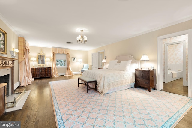 bedroom featuring an inviting chandelier, hardwood / wood-style floors, a high end fireplace, and ornamental molding