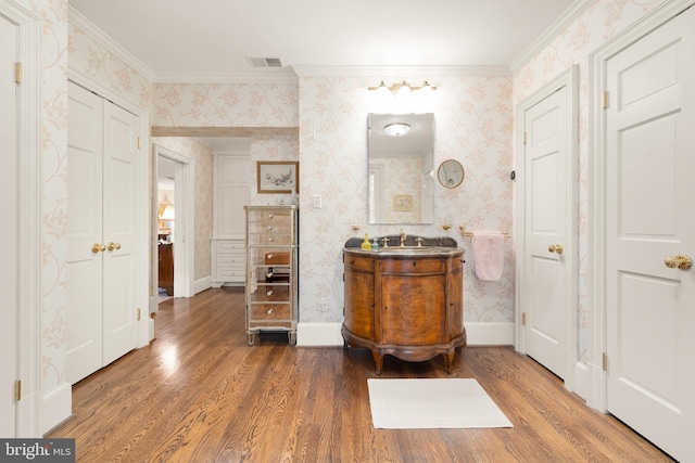 bathroom featuring vanity, hardwood / wood-style flooring, and ornamental molding