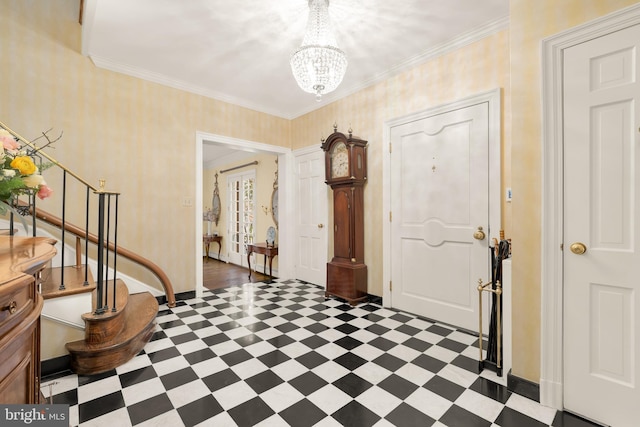 foyer entrance with crown molding and an inviting chandelier