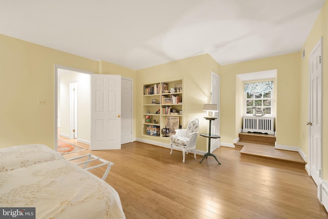 bedroom with wood-type flooring and radiator heating unit