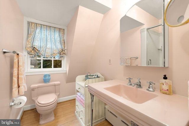 bathroom featuring sink, hardwood / wood-style flooring, a shower with door, and toilet