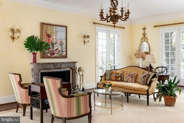 sitting room featuring a notable chandelier, crown molding, a fireplace, and french doors