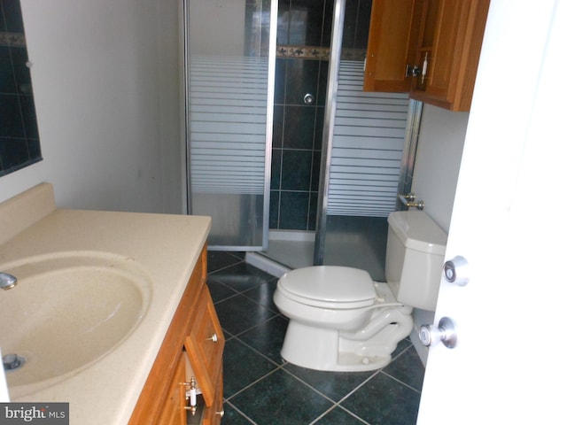 bathroom with vanity, toilet, an enclosed shower, and tile patterned floors