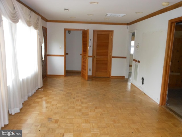 empty room featuring light parquet flooring and crown molding