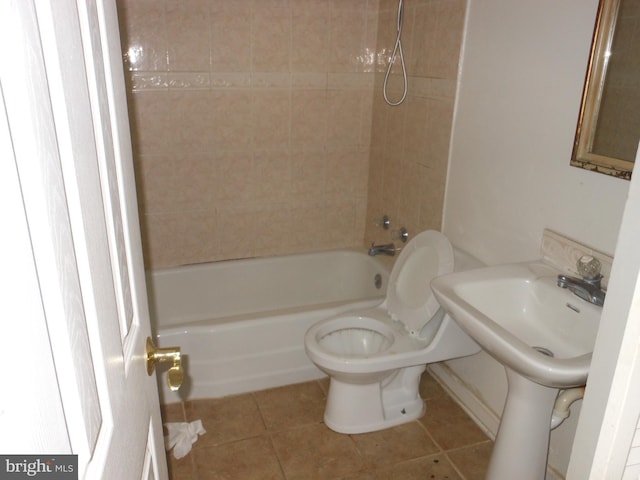 bathroom featuring tile patterned flooring, tiled shower / bath combo, and toilet