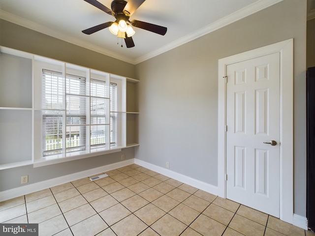 tiled empty room with ceiling fan and ornamental molding