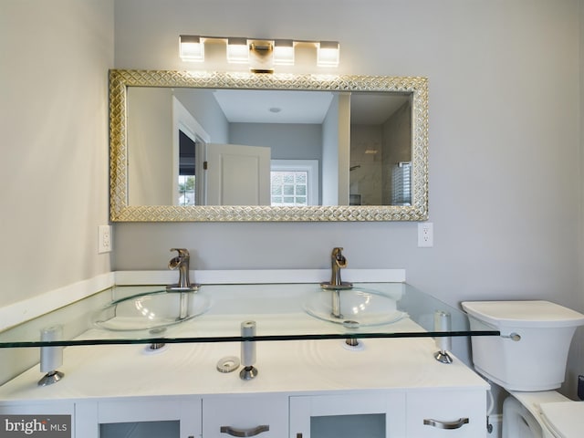 bathroom with walk in shower, vanity, and toilet