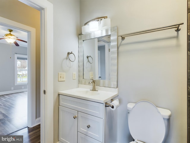 bathroom with hardwood / wood-style floors, vanity, toilet, and ceiling fan