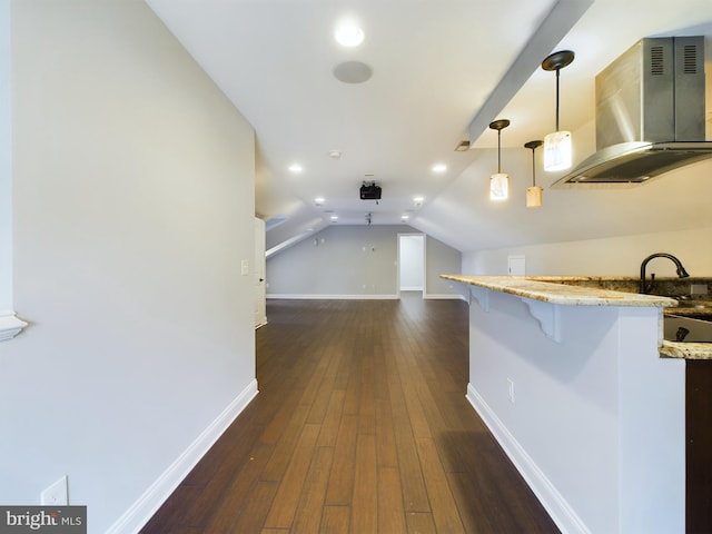 kitchen with lofted ceiling, island range hood, a kitchen bar, decorative light fixtures, and dark hardwood / wood-style flooring