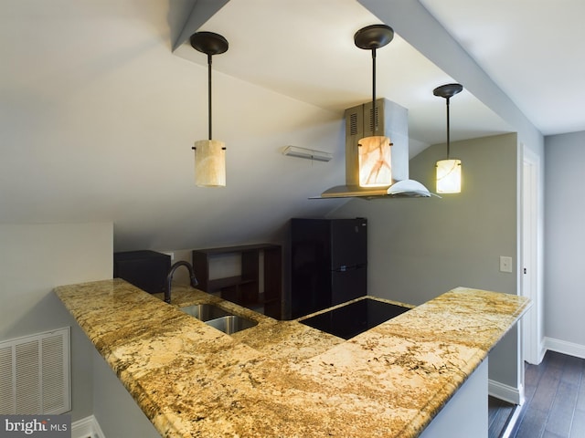 kitchen with pendant lighting, sink, kitchen peninsula, black appliances, and dark hardwood / wood-style flooring