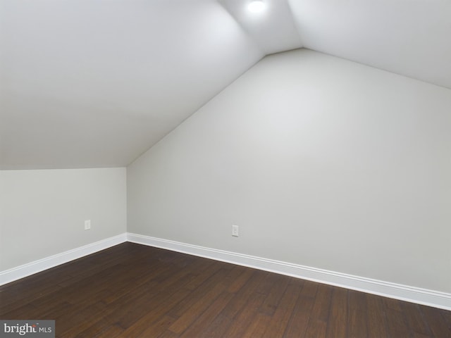 bonus room featuring vaulted ceiling and dark wood-type flooring