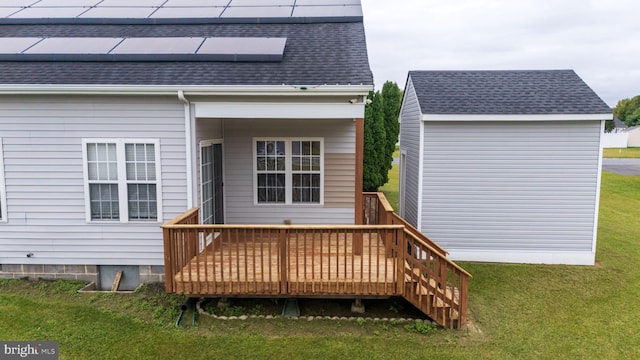 back of property featuring solar panels, a deck, and a yard