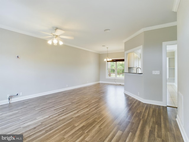 unfurnished living room with ceiling fan with notable chandelier, dark hardwood / wood-style floors, ornamental molding, and sink