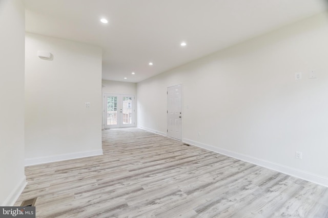 empty room featuring french doors and light hardwood / wood-style floors