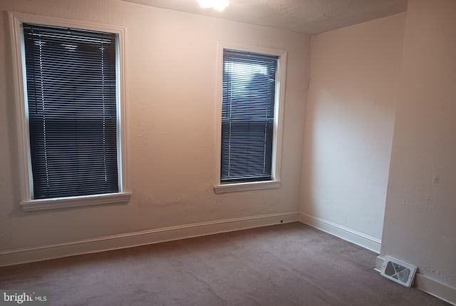 carpeted empty room with baseboards and visible vents