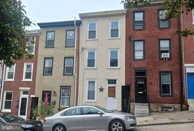 townhome / multi-family property featuring cooling unit, stucco siding, and entry steps