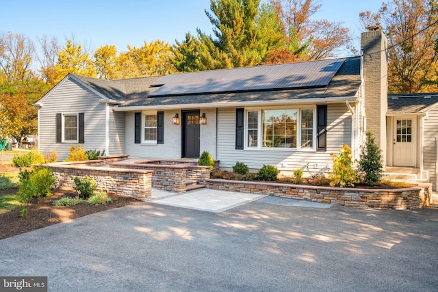 single story home featuring solar panels