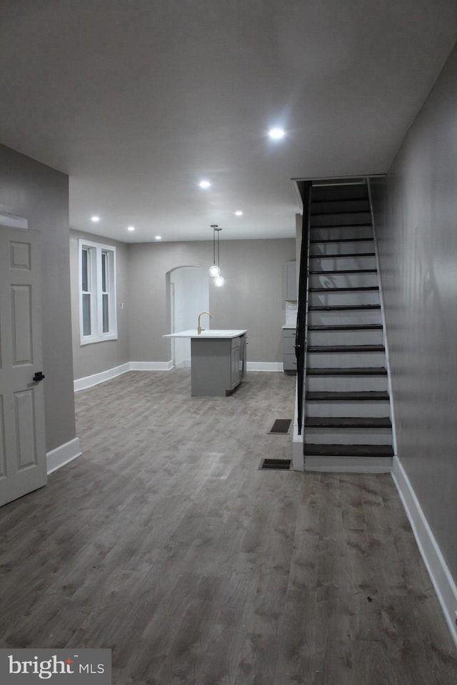 basement featuring sink and hardwood / wood-style floors