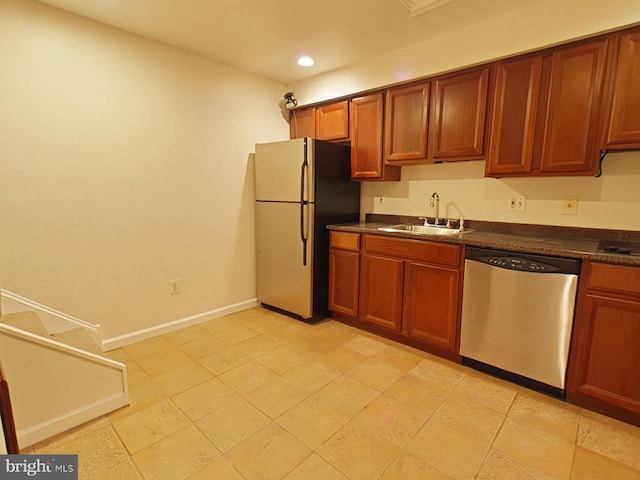 kitchen with appliances with stainless steel finishes, sink, and light tile patterned floors