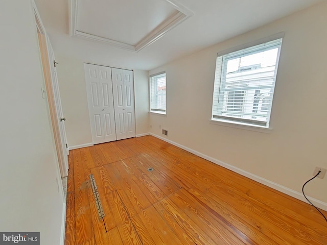 unfurnished bedroom with light hardwood / wood-style flooring and a closet