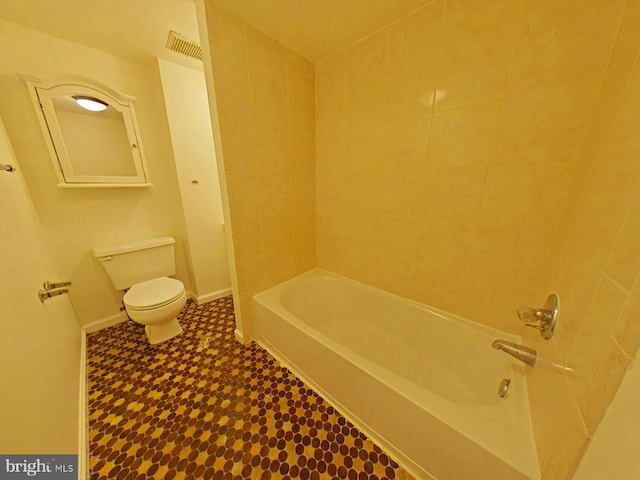 bathroom featuring tiled shower / bath and toilet