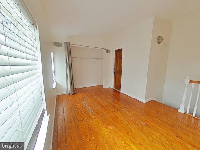 unfurnished bedroom with hardwood / wood-style floors and a closet