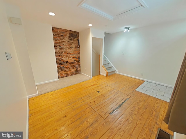 unfurnished living room featuring crown molding and hardwood / wood-style floors