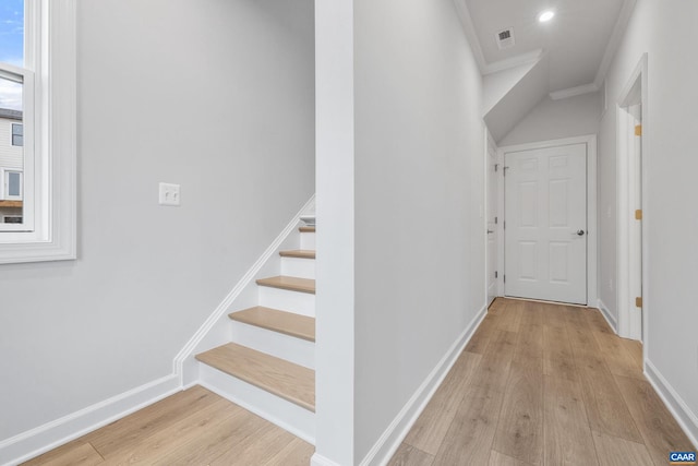 stairway featuring ornamental molding and wood-type flooring