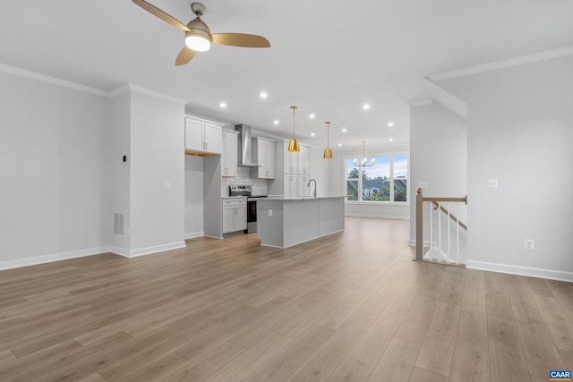 unfurnished living room featuring ceiling fan, sink, light hardwood / wood-style flooring, and ornamental molding