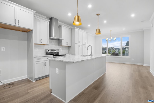 kitchen with wall chimney exhaust hood, white cabinets, and sink