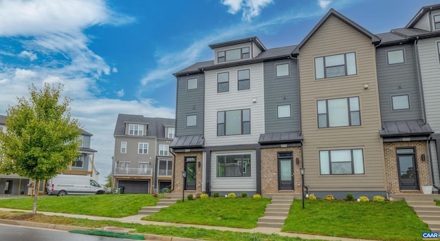 townhome / multi-family property featuring a front lawn and a garage