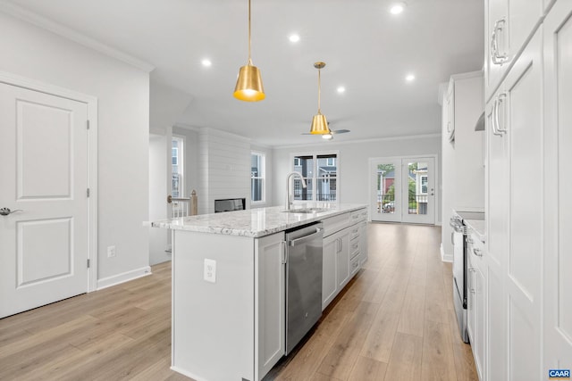 kitchen featuring appliances with stainless steel finishes, hanging light fixtures, white cabinets, a kitchen island with sink, and sink