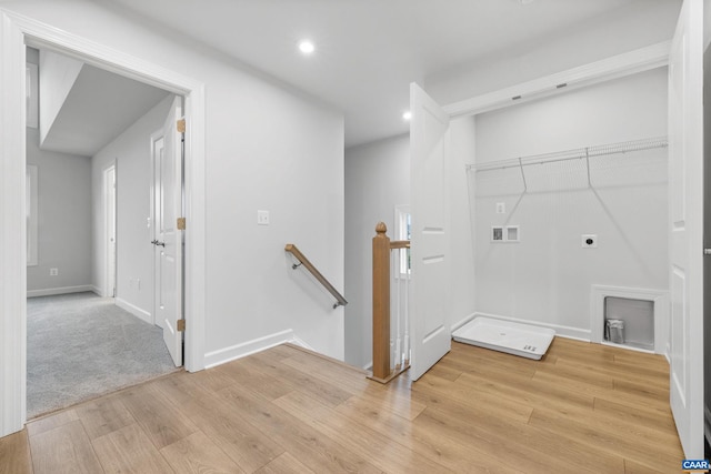 clothes washing area with hookup for an electric dryer, washer hookup, and light hardwood / wood-style flooring