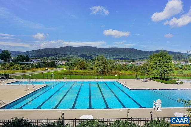 view of pool with a lawn, a mountain view, and a patio area