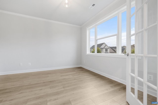 empty room with ornamental molding and light hardwood / wood-style flooring