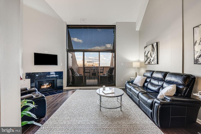 living room with lofted ceiling, dark hardwood / wood-style floors, and a tile fireplace